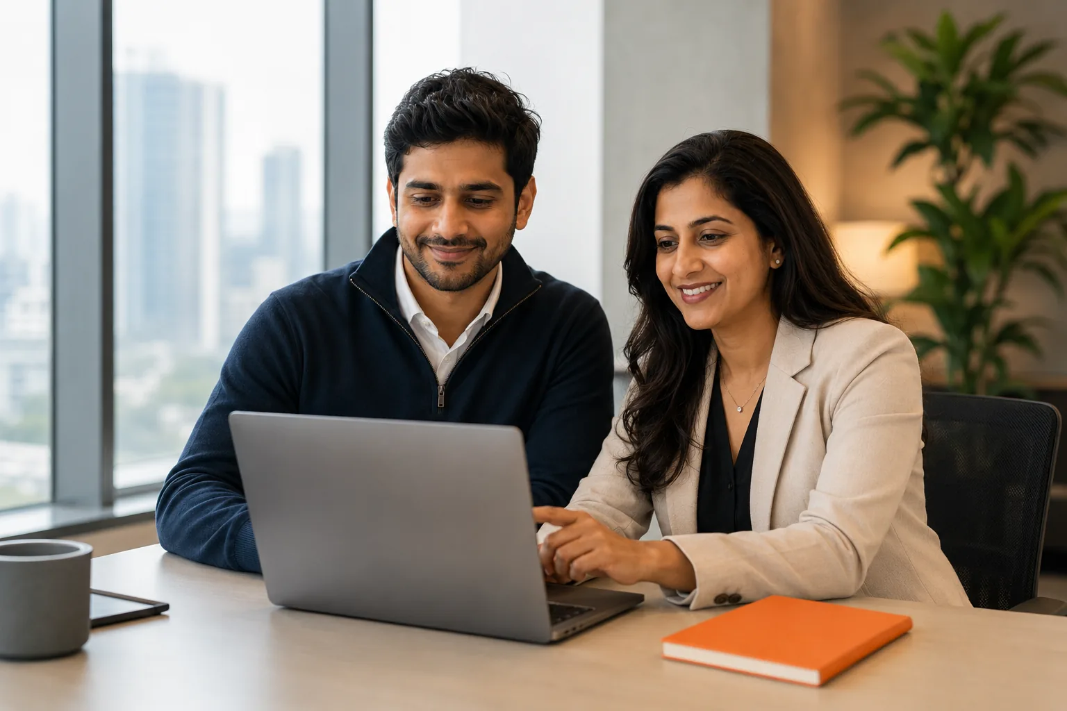 Two InstaSafe colleagues working through something together at a laptop in the Bengaluru office